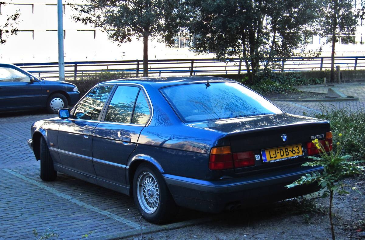BMW 525i řady E34 zaparkované u chodníku