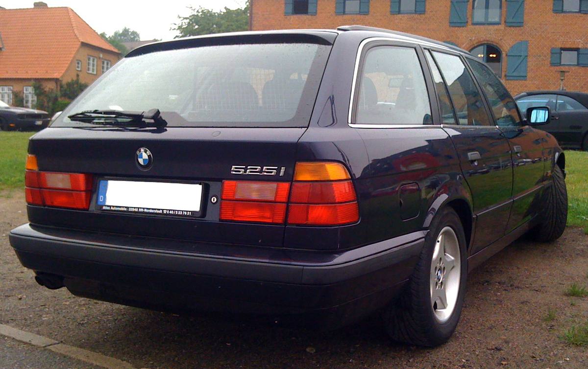 Záď modrého kombi BMW řady E34 se zavřeným víkem zavazadlového prostoru