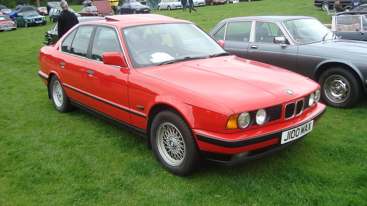 BMW 518i řady E34 zaparkované u chodníku, pohled zepředu z boku