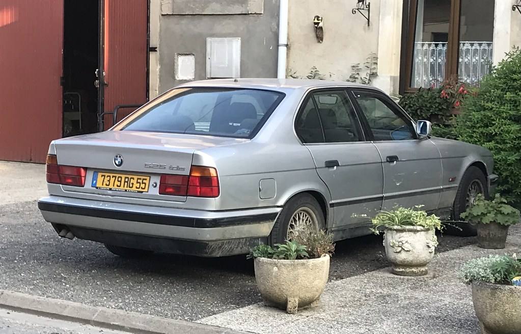 Tmavě zelené BMW 525tds řady E34 zaparkované bokem ke kameře