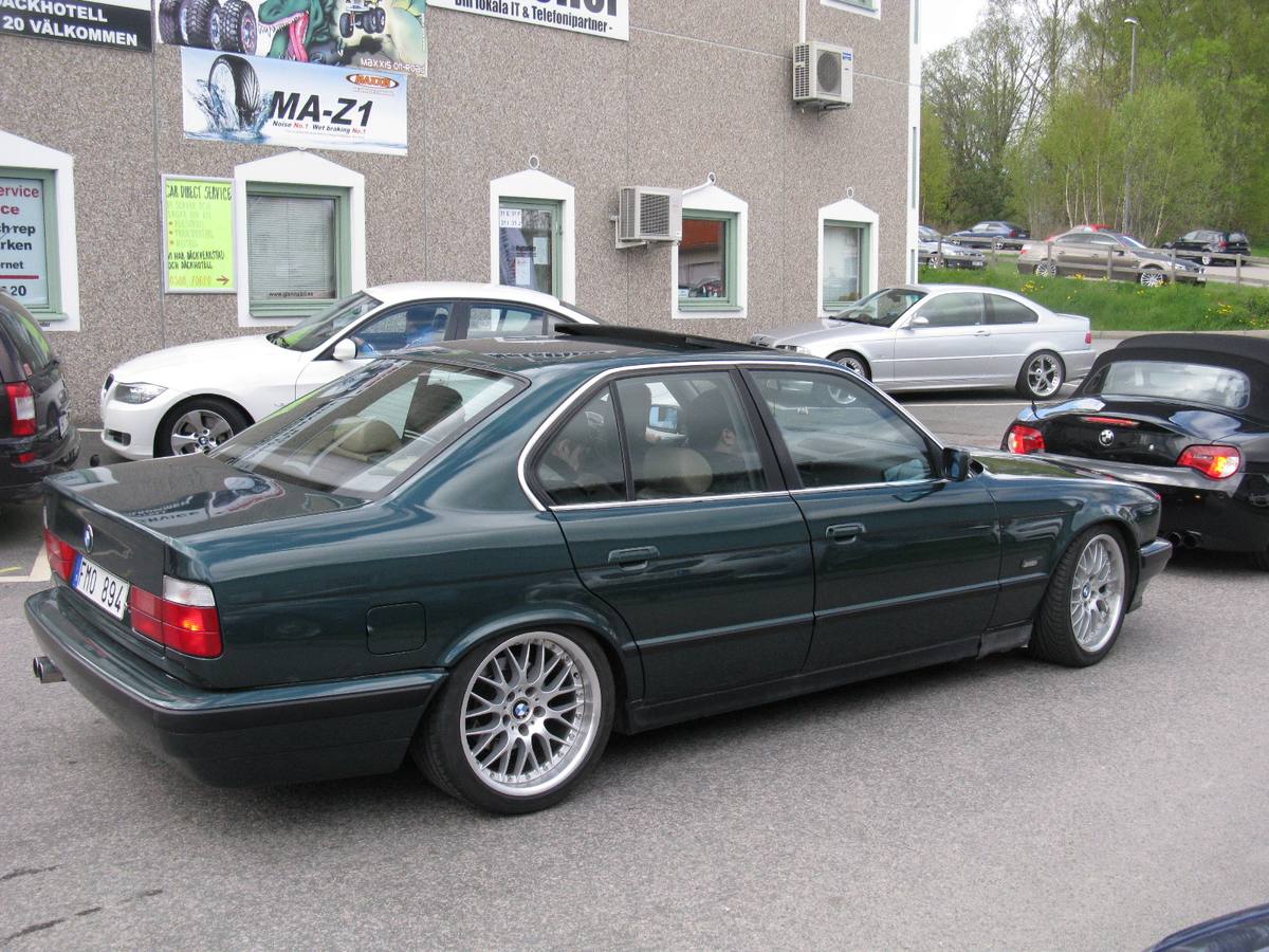 Zelený sedan BMW řady E34 zaparkovaný na parkovišti