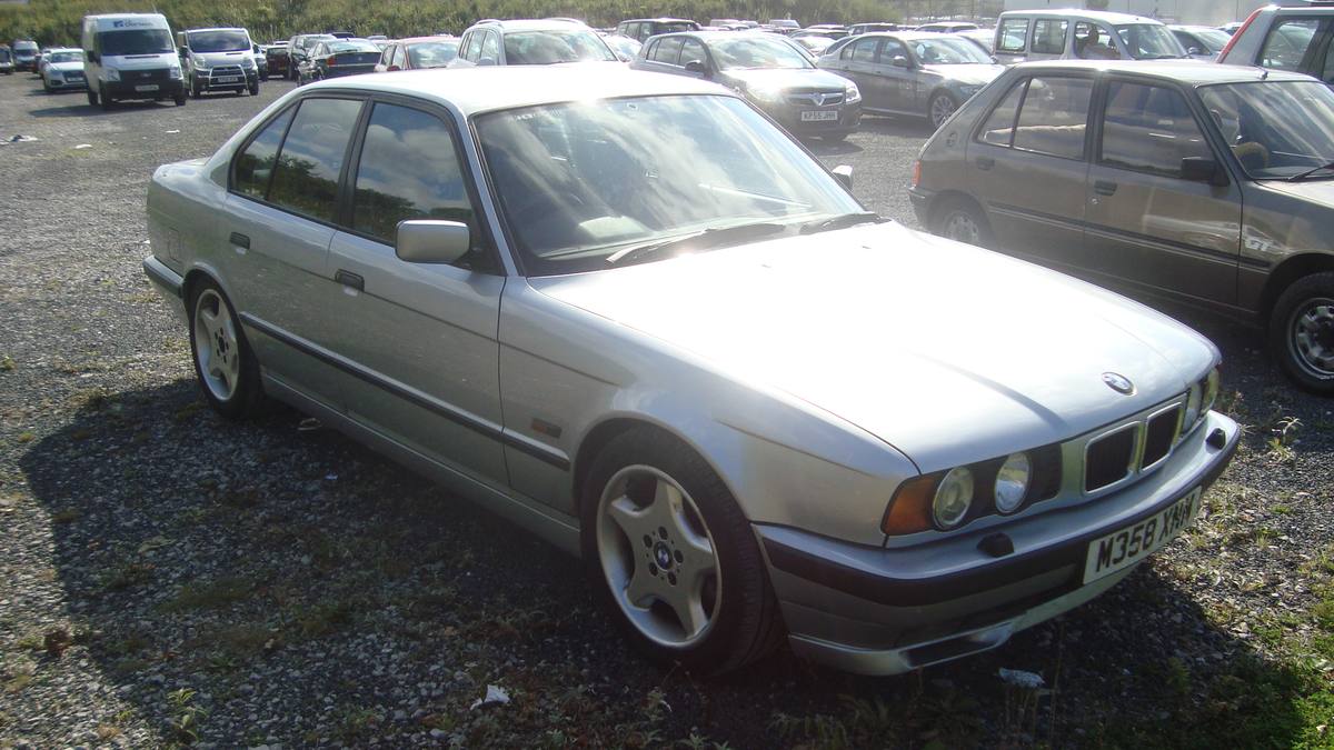 Stříbrné BMW 540i řady E34 s automatem na parkovišti