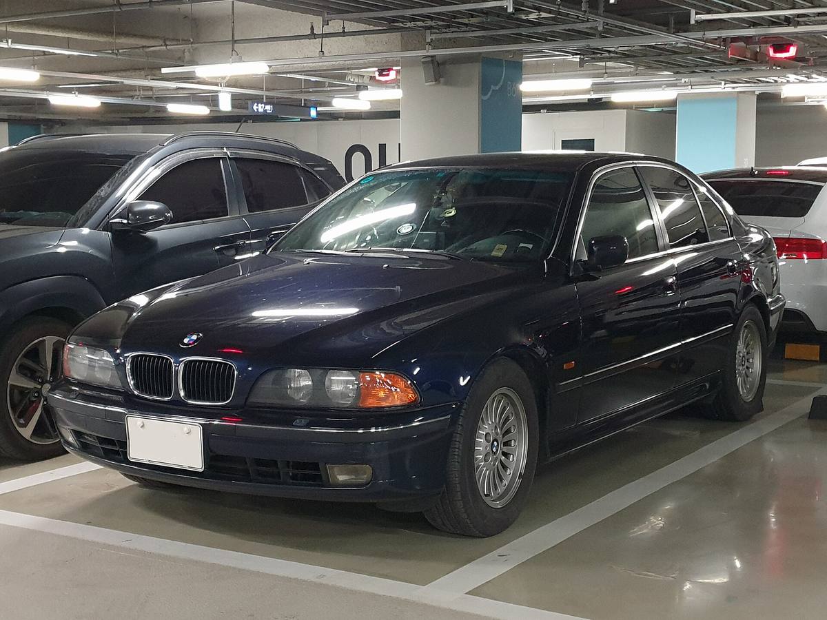 Modrý sedan BMW 528i generace E39 zepředu z boku