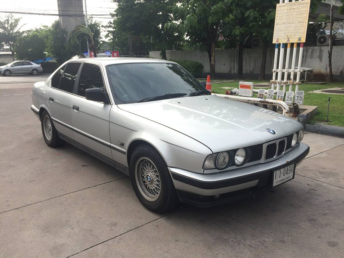 Sedan BMW 520i řady E34 zaparkovaný na ulici