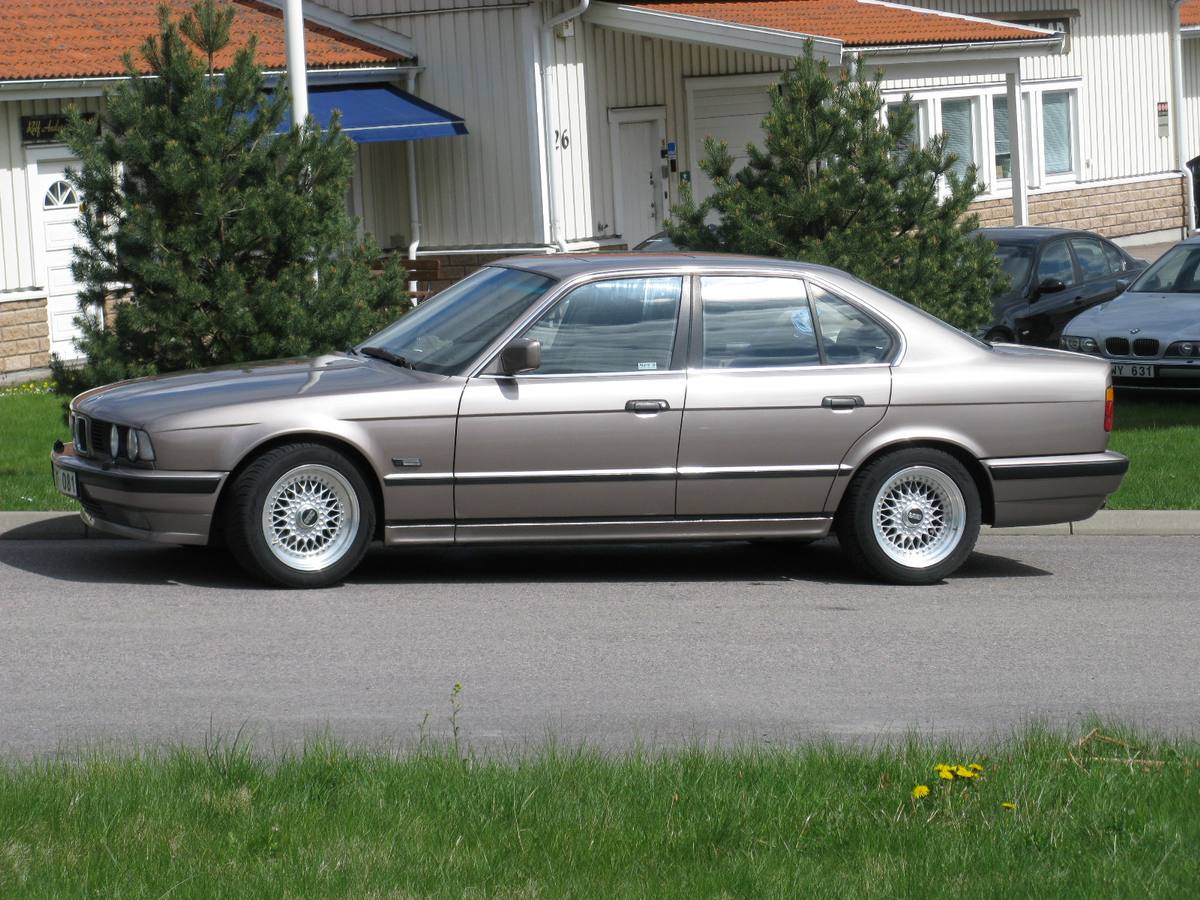 Bok sedanu BMW 530i z řady E34 s koly s křížovými paprsky