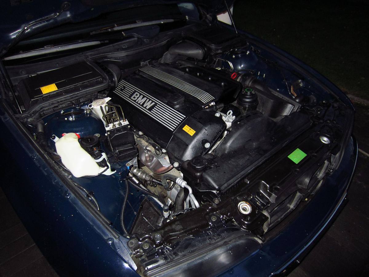 Motorový prostor BMW E39 523i z modelového roku 1999 s hydraulickým blokem brzd u věže tlumiče