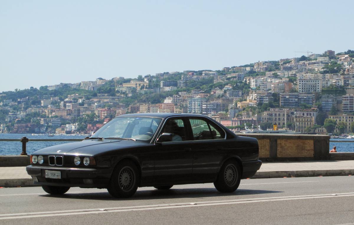 BMW 520i generace E34 zaparkované u obrubníku