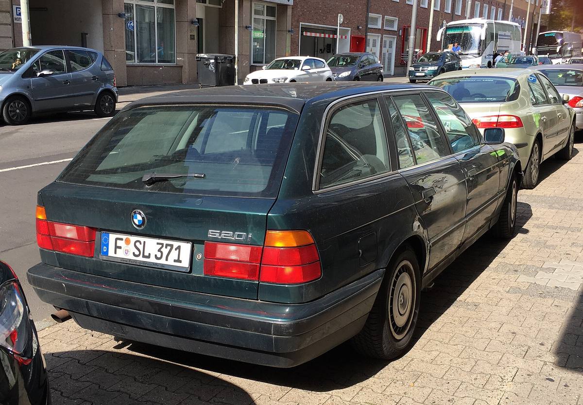 BMW 520i Touring z řady E34 zaparkované u chodníku