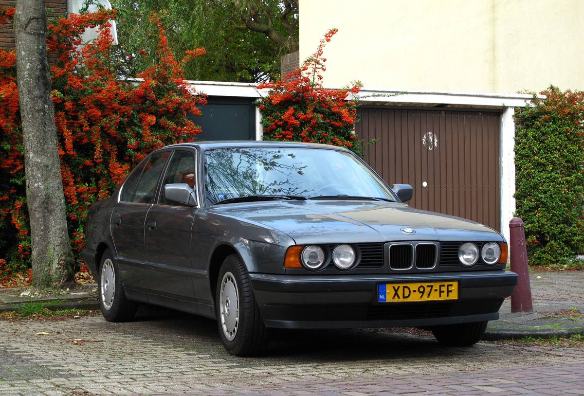 Šedé BMW 520i generace E34 zaparkované v ulici