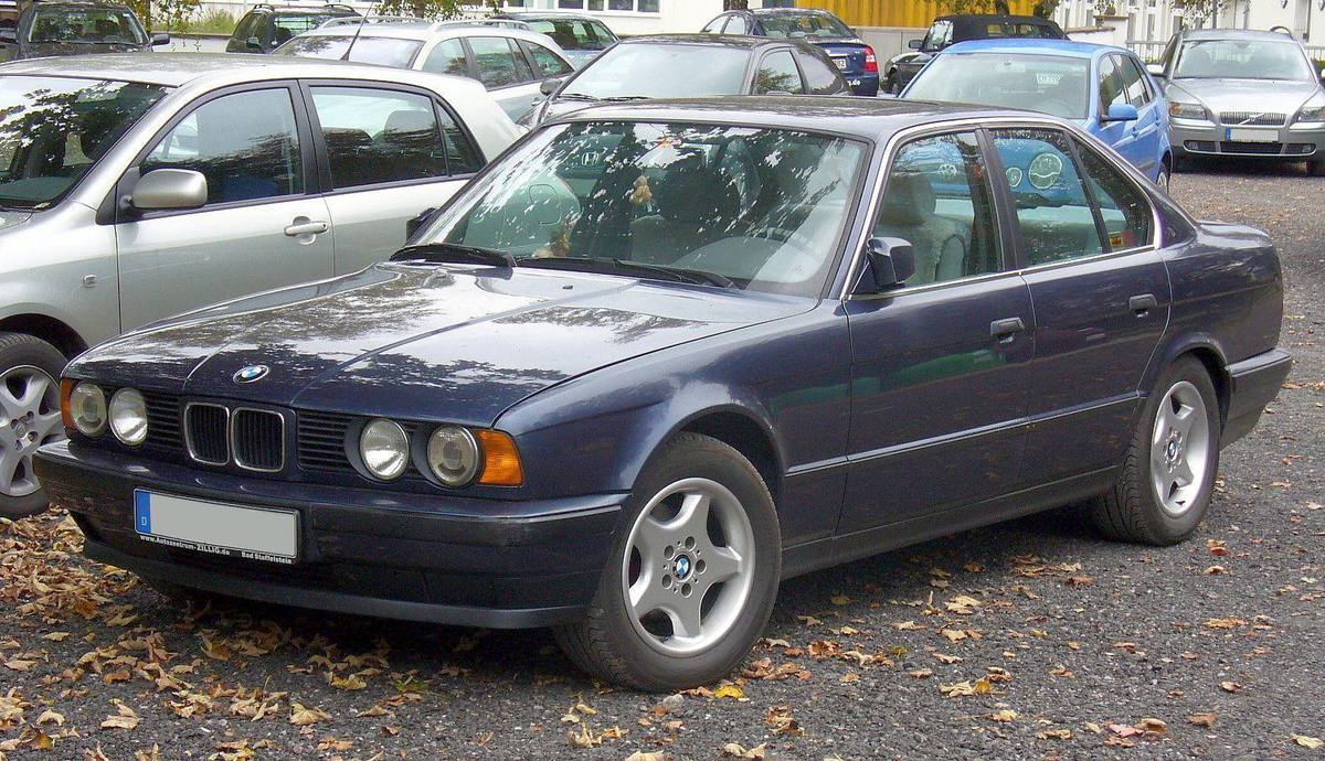 Tmavomodrý sedan BMW E34 se dvojicí kulatých světlometů na každé straně