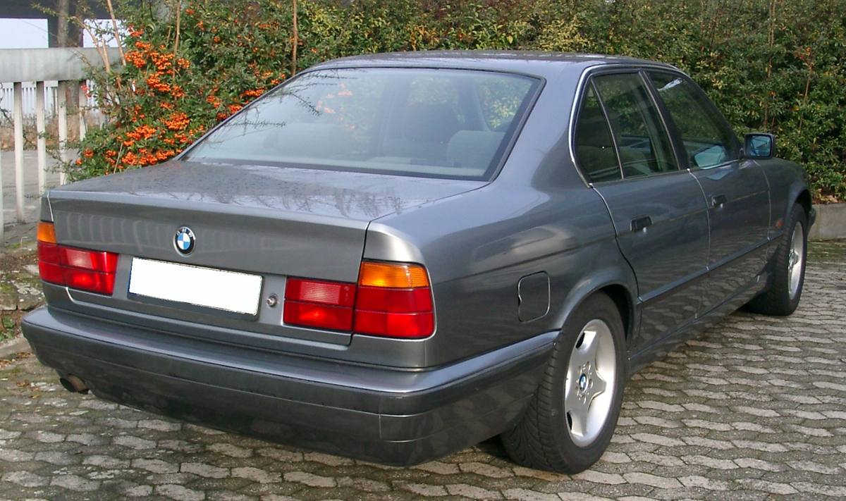 Záď stříbrného sedanu BMW řady E34 se zadními světly