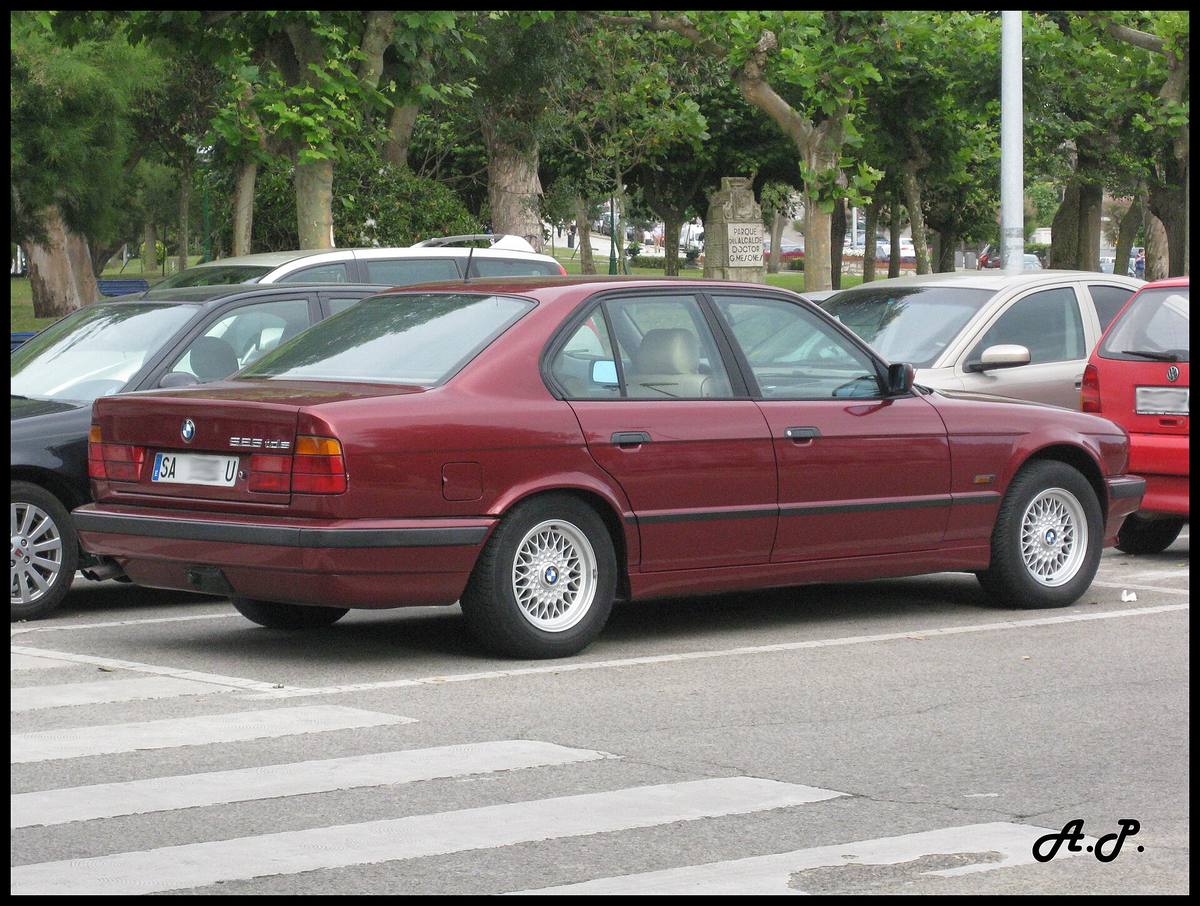 Sedan BMW 525tds generace E34 zaparkovaný u chodníku