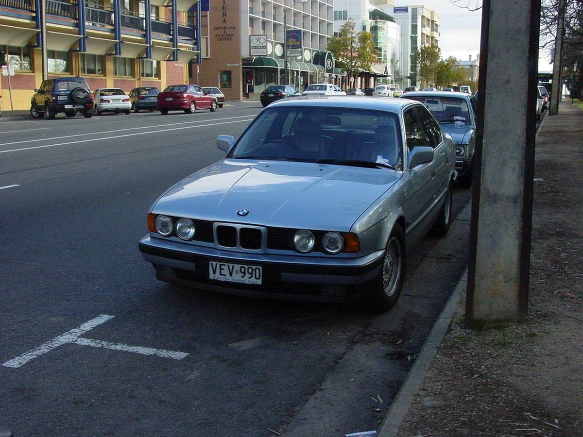 Stříbrné BMW 535i řady E34 zaparkované u chodníku