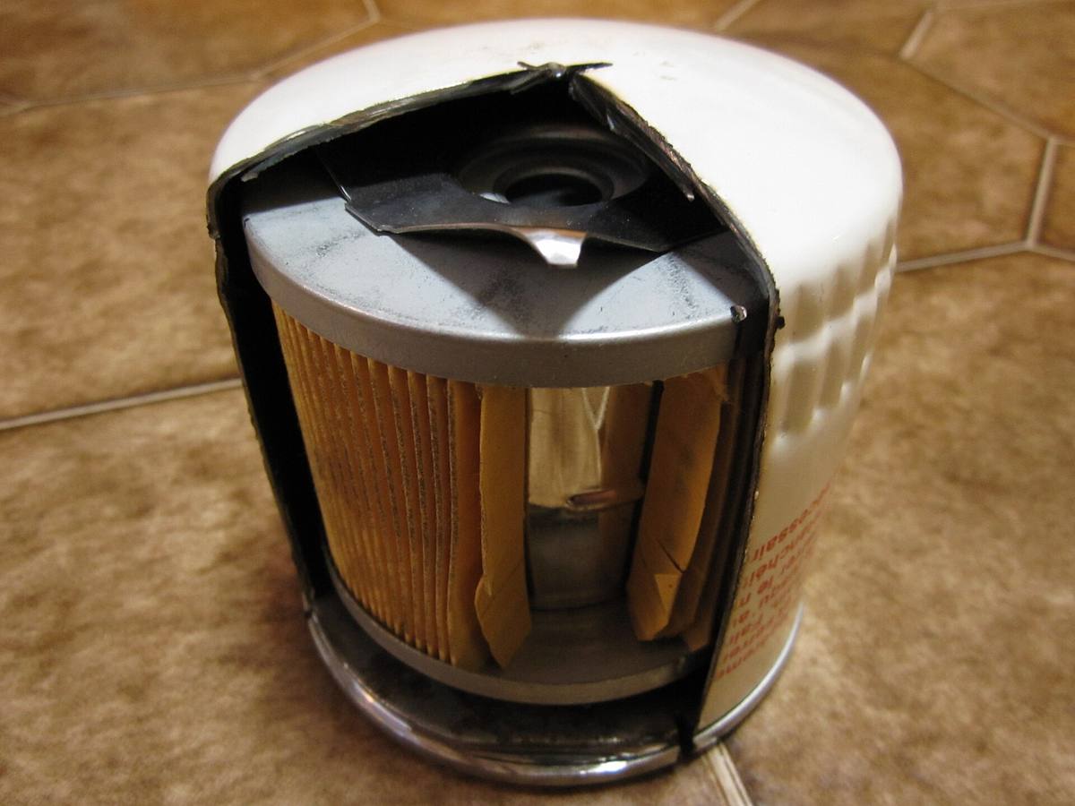 Rozříznutá nádobka šroubovacího olejového filtru s papírovou vložkou uvnitř