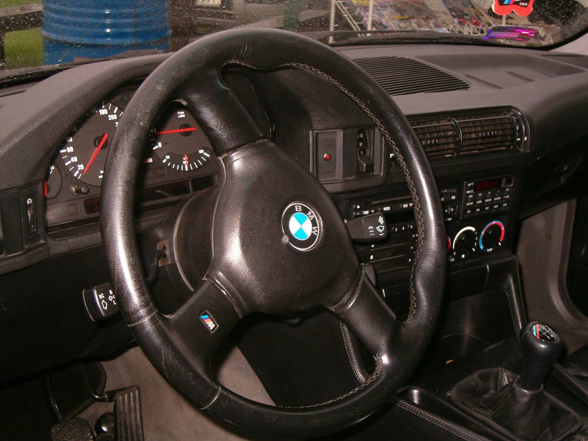 Palubní deska BMW M5 z řady E34, vpravo dole řadicí páka s koženou manžetou
