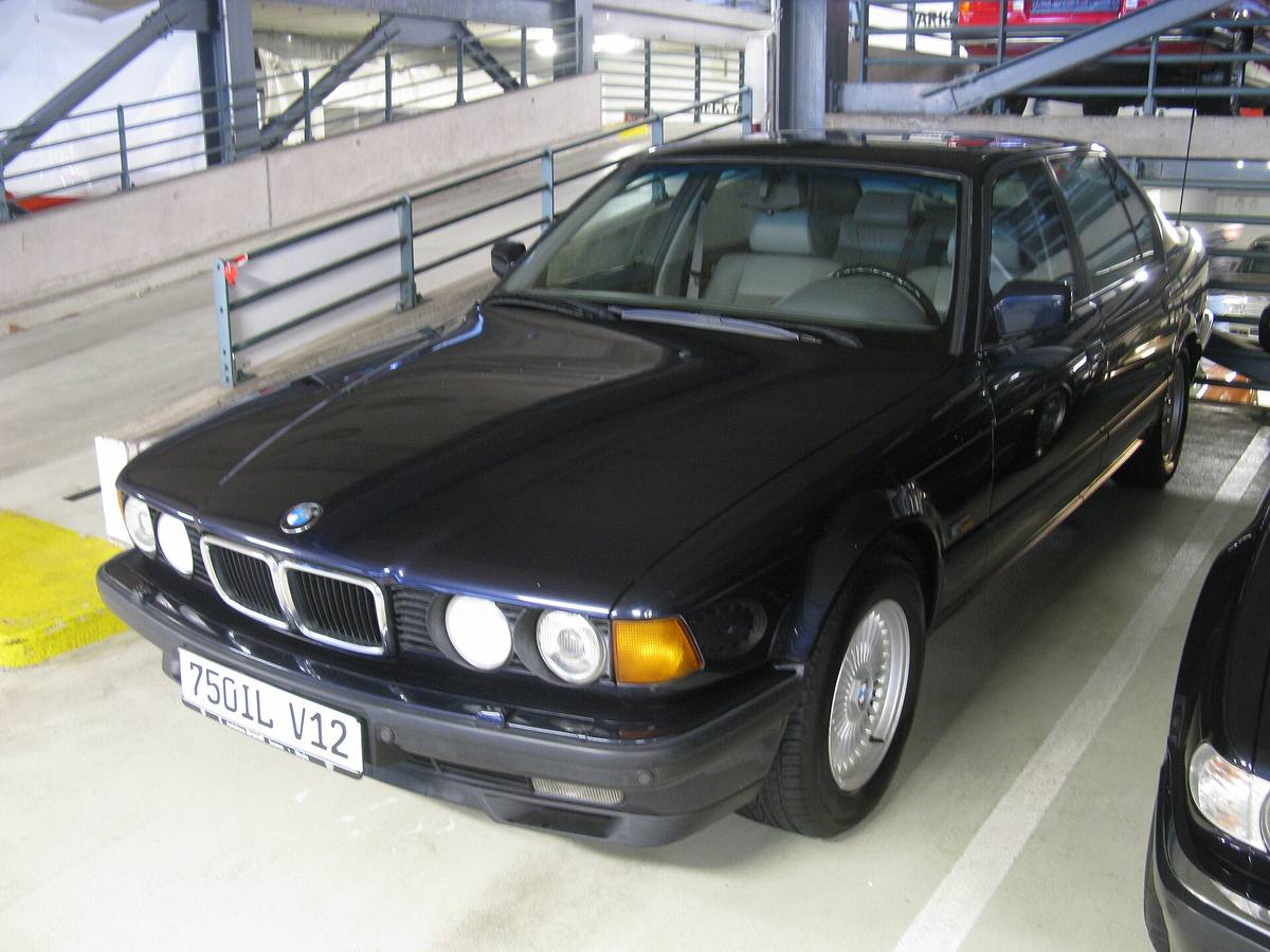 Tmavě modré BMW 750iL generace E32 zepředu, se čtyřmi kulatými světlomety a širokou ledvinovou maskou