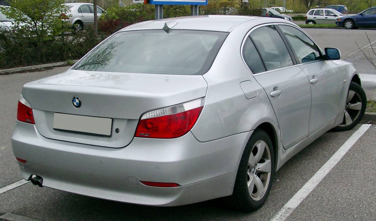 Stříbrný sedan BMW E60 zezadu na parkovišti