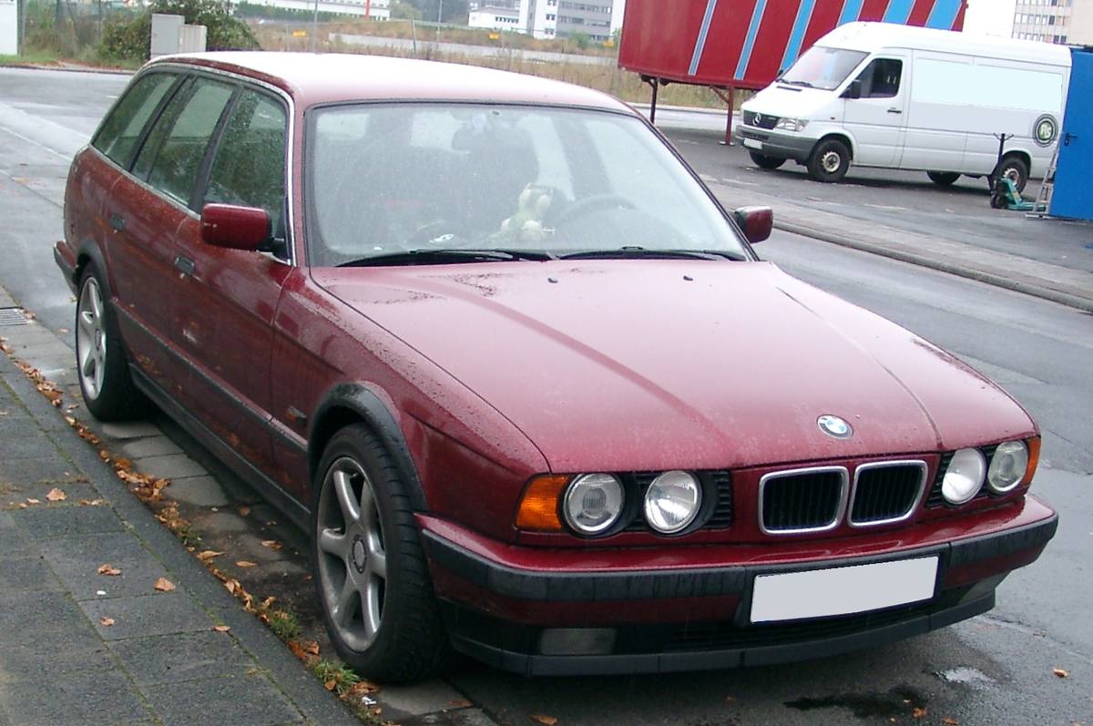 BMW E34 Touring zepředu, s ramenem stěračů v parkovací poloze pod hranou kapoty
